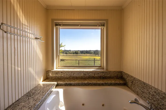 a bathroom with a granite countertop sink and a window