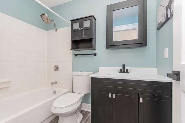 a bathroom with a sink toilet vanity tub and shower