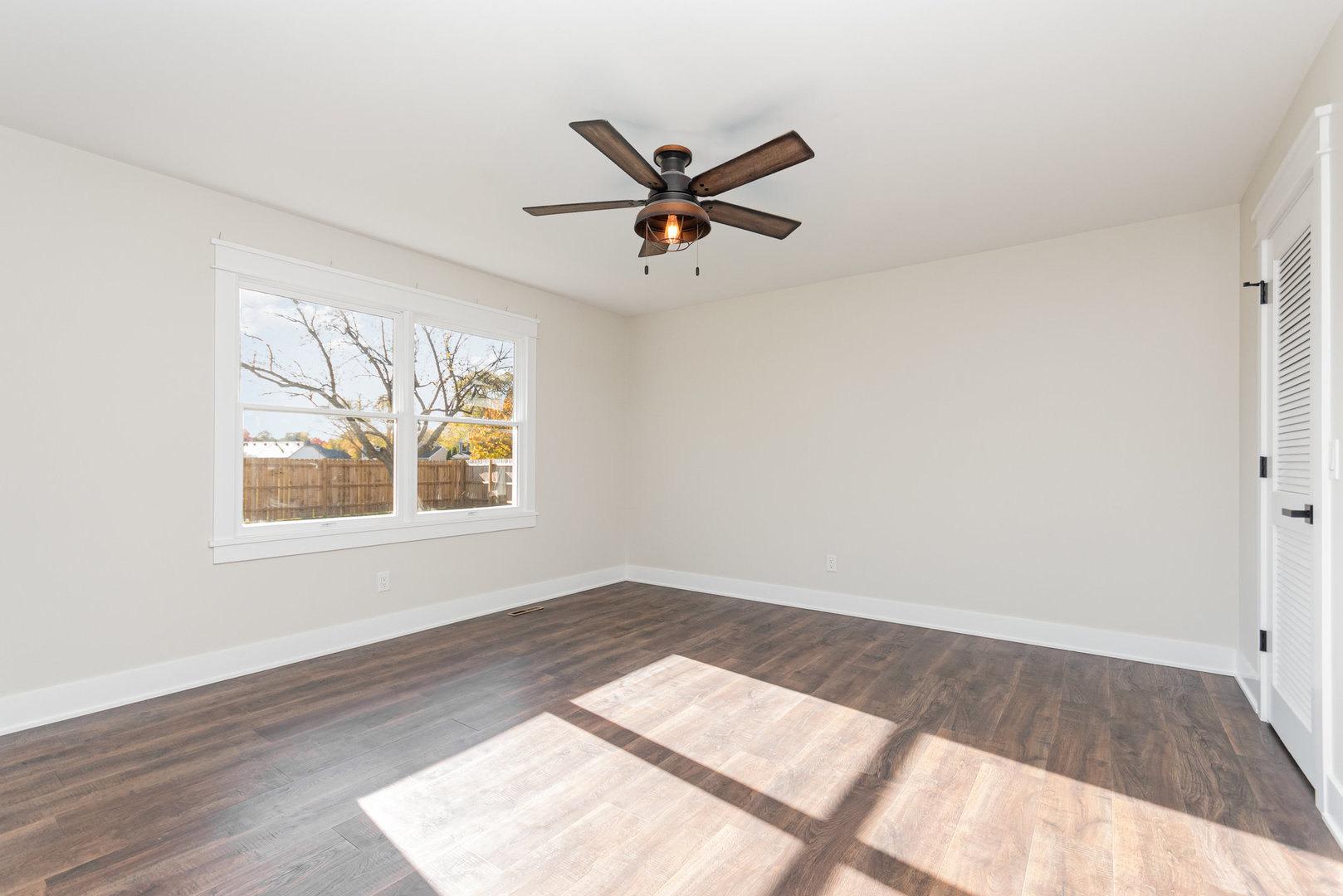 22 Sherwick Road Oswego, IL 60543 - Photo 14 of 29 an empty room with wooden floor chandelier fan and windows