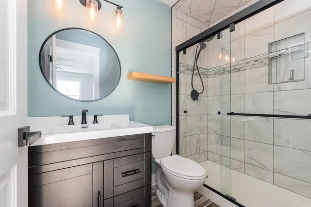 a bathroom with a sink a toilet and a mirror