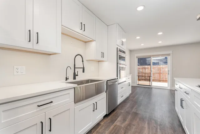 a kitchen with granite countertop a sink stainless steel appliances and cabinets