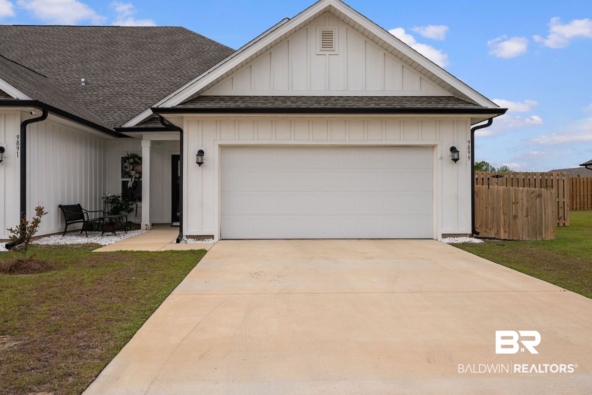 9899 Willet Way Foley, AL 36535 - Photo 36 of 37 Modern facade featuring white board and batten siding, black trim, and a prominent garage door