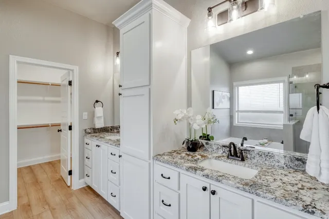 a bathroom with a granite countertop sink and a mirror