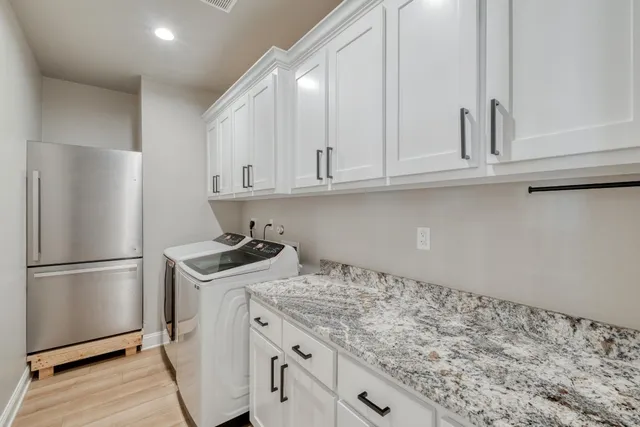 a kitchen with a sink a refrigerator and cabinets