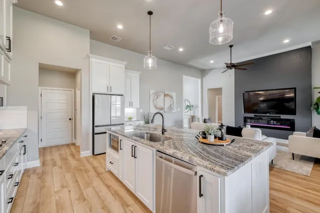 a kitchen with granite countertop a sink appliances and cabinets