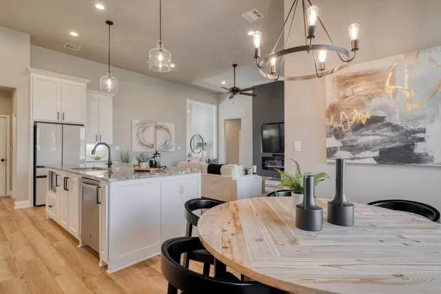 a kitchen with sink a refrigerator and chairs