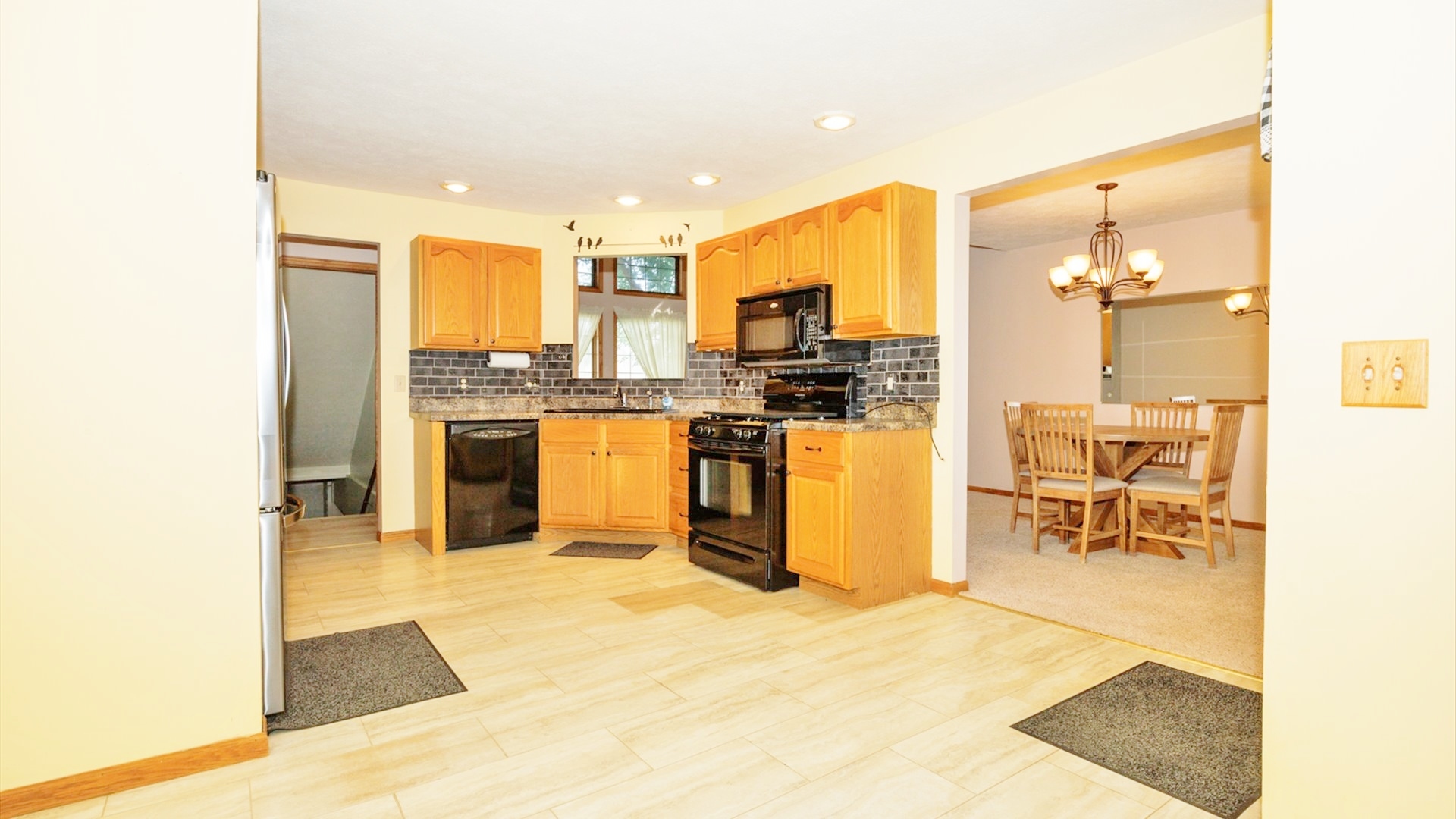 411 Wildberry Drive Normal, IL 61761 - Photo 12 of 51 a kitchen with stainless steel appliances kitchen island granite countertop a sink and cabinets