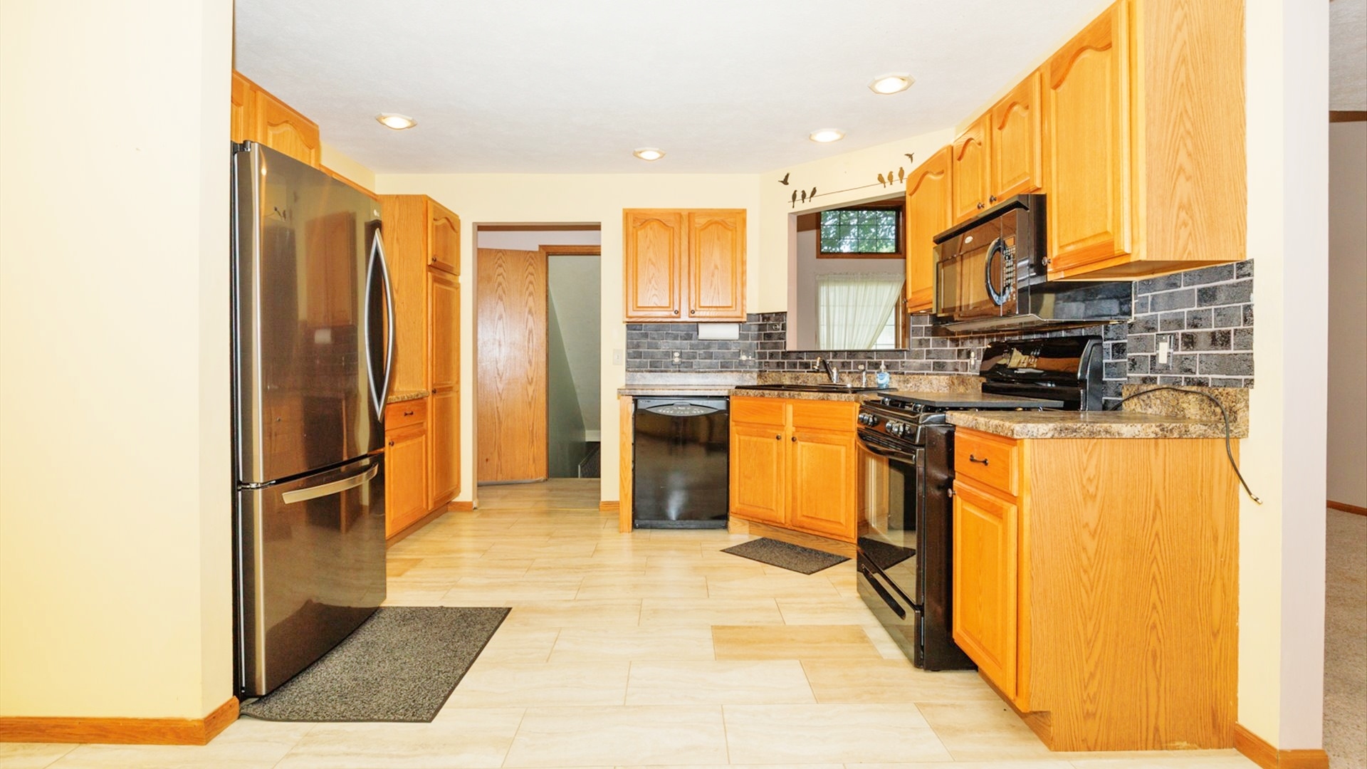 411 Wildberry Drive Normal, IL 61761 - Photo 13 of 51 a kitchen with stainless steel appliances granite countertop a refrigerator a stove and a sink with wooden floor