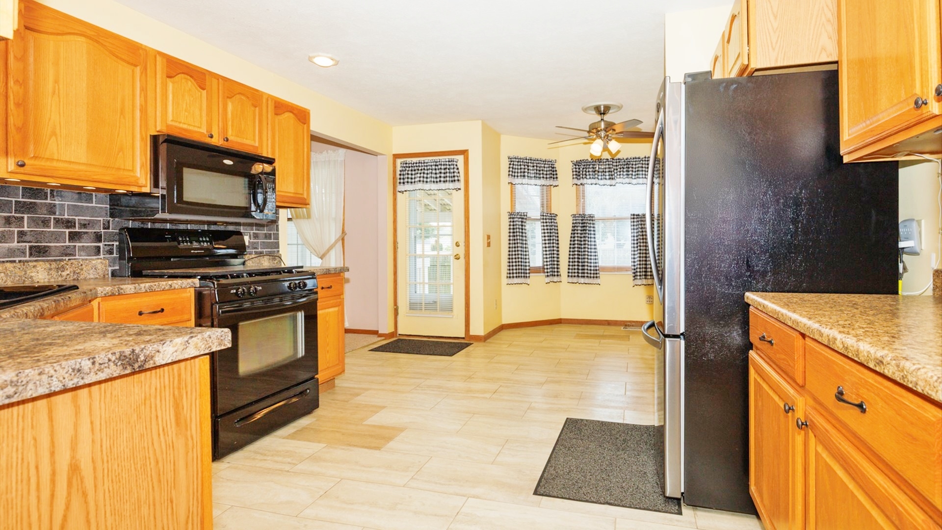 411 Wildberry Drive Normal, IL 61761 - Photo 10 of 51 a kitchen with stainless steel appliances granite countertop a refrigerator a stove and a sink with wooden floor