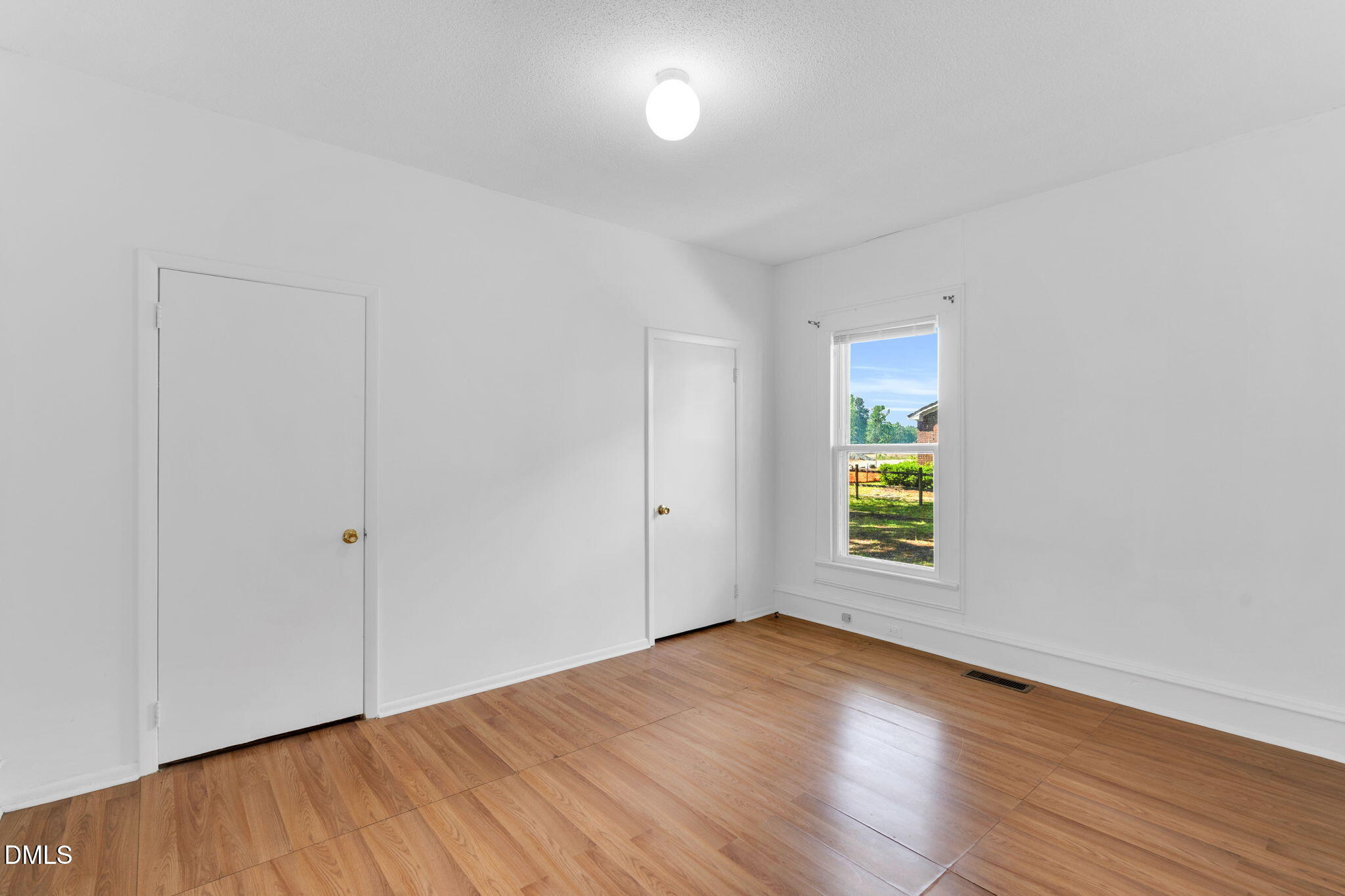 310 Chicopee Road Benson, NC 27504 - Photo 6 of 23 an empty room with wooden floor and windows