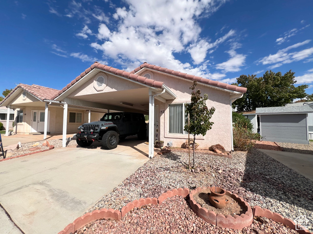 2990 East Riverside Drive St. George, UT 84790 - Photo 1 of 1 View of front of property with a carport, stucco siding, concrete driveway, and a tiled roof
