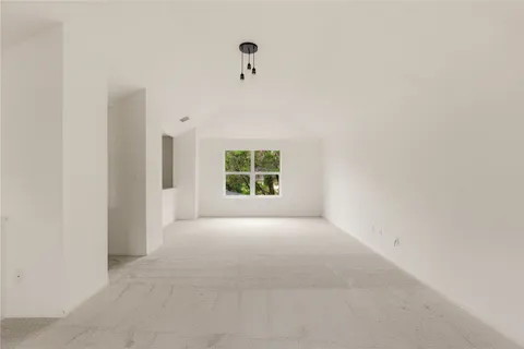 an empty room with windows and ceiling fan