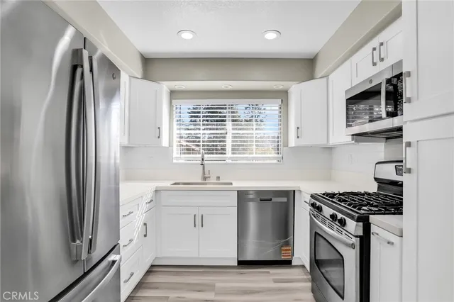 a kitchen with stainless steel appliances granite countertop a stove a sink and a refrigerator