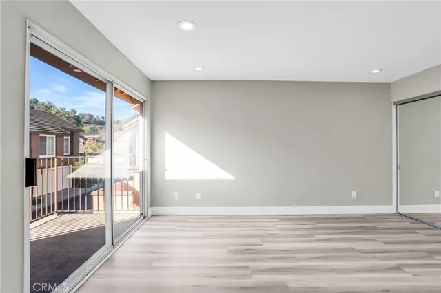 a view of a room with wooden floor and windows
