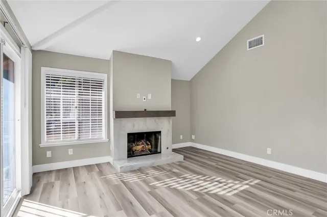 a view of an empty room with a window and fire place