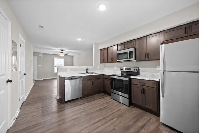 a view of a kitchen with a sink stove and refrigerator
