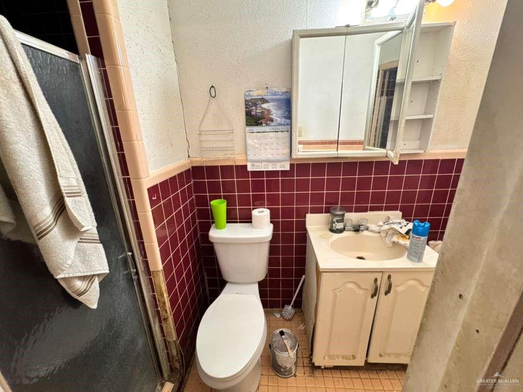 421 South Main Street Donna, TX 78537 - Photo 17 of 24 a bathroom with a sink a toilet and a mirror