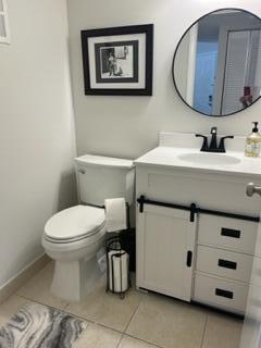 1605 Highway 1, Unit F204 Jupiter, FL 33477 - Photo 12 of 33 a bathroom with a toilet a sink and mirror