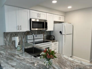 1605 Highway 1, Unit F204 Jupiter, FL 33477 - Photo 8 of 33 a kitchen with stainless steel appliances a refrigerator sink and microwave