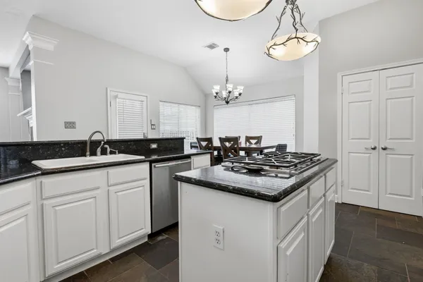 a kitchen with sink stove and cabinets