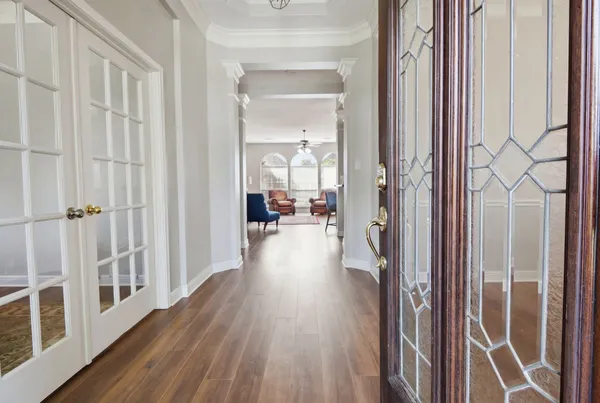 a view of a hallway with wooden floor and staircase
