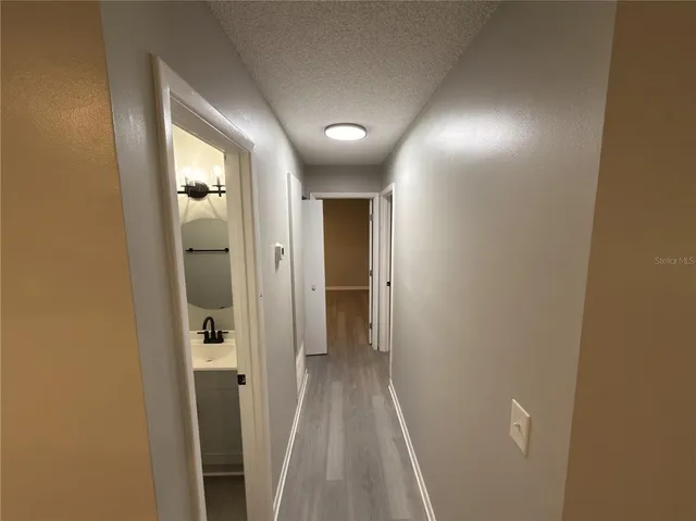 a view of a hallway with wooden floor