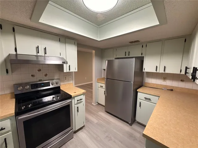 a kitchen with a stove a refrigerator and a sink