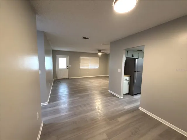 a view of a room with wooden floor and electronic appliances