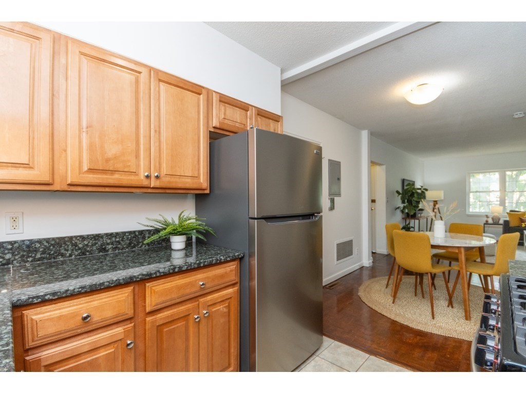 132 Lake Shore Road, Unit 1 Boston, MA 02135 - Photo 8 of 31 a kitchen with stainless steel appliances granite countertop a refrigerator and a stove top oven