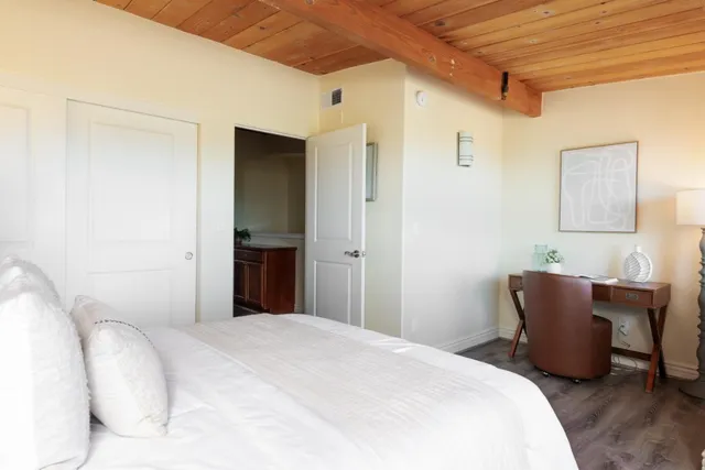 a bedroom with a bed and a painting on the wall