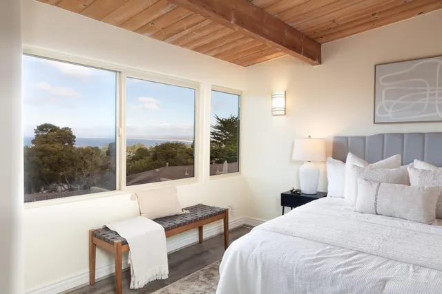 a bedroom with a bed and a large window with outer view