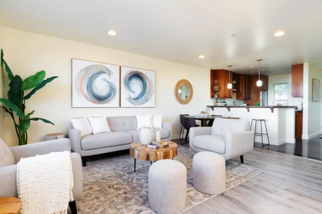 a living room with furniture a couch and kitchen view