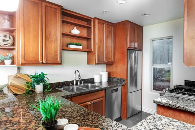 a kitchen with granite countertop a stove a sink and a microwave