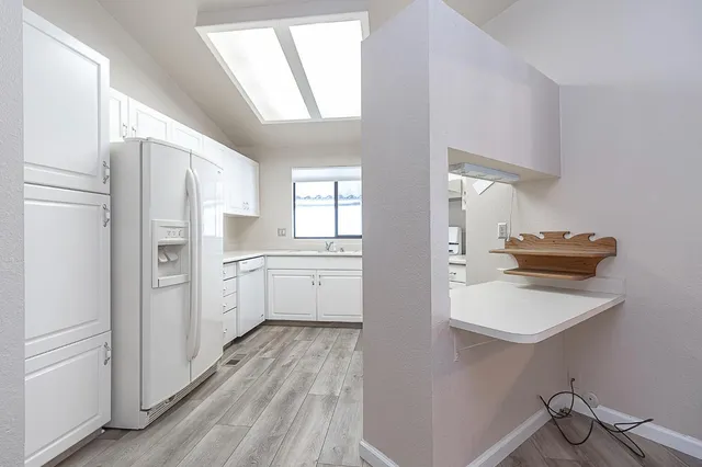 a kitchen with white cabinets and white appliances