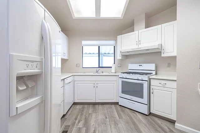 a kitchen with cabinets appliances and a window