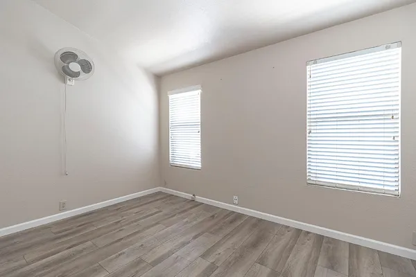 an empty room with a window and a ceiling fan