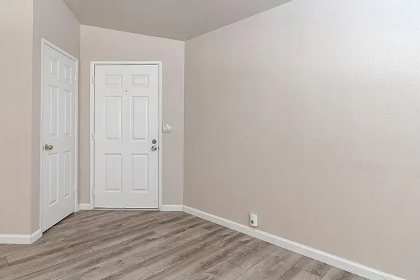 a view of an empty room with wooden floor