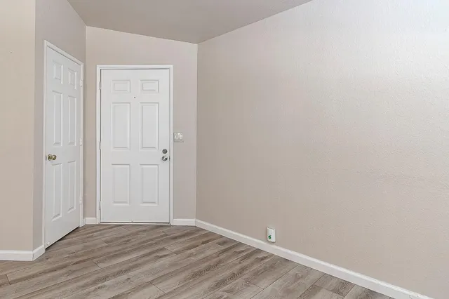 a view of an empty room with wooden floor