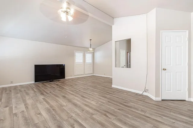 a view of empty room with wooden floor and fireplace