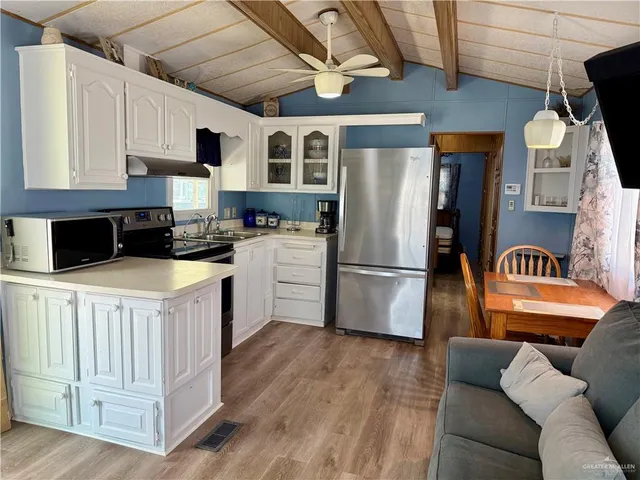 a kitchen with stainless steel appliances granite countertop a refrigerator a stove a sink and a microwave