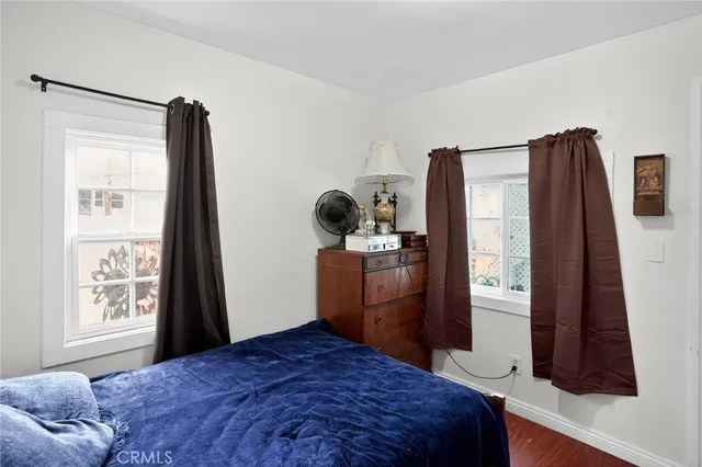 a bedroom with a bed and dresser with mirror