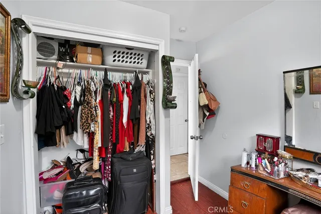 a view of walk in closet with clothes and shoes