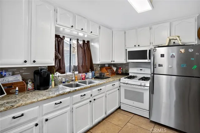 a kitchen with white cabinets and white appliances