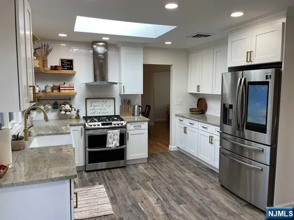 a kitchen with stainless steel appliances granite countertop a sink stove and cabinets