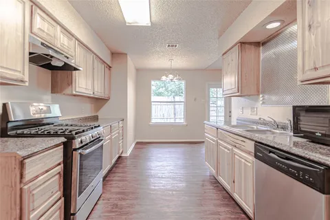 a kitchen with stainless steel appliances granite countertop a stove and a sink