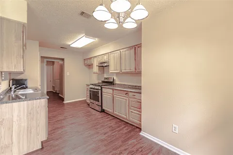 a kitchen with a refrigerator cabinets and wooden floor
