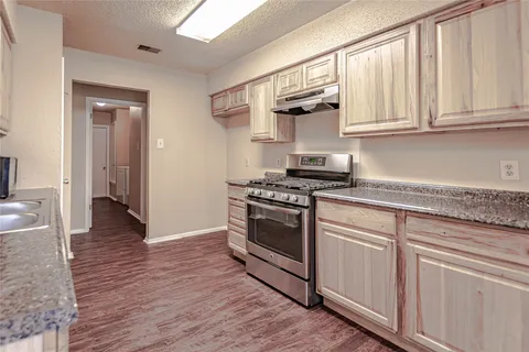 a kitchen with stainless steel appliances granite countertop a stove and a sink