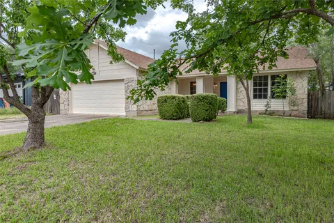 a view of a house with backyard and a tree
