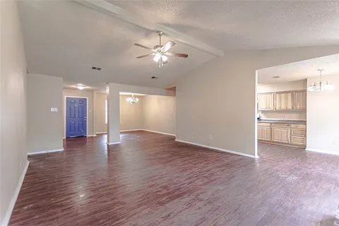 a view of an empty room with window and wooden floor