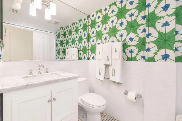 a bathroom with a granite countertop sink a toilet and a mirror